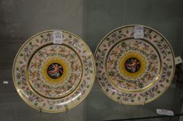 A pair of KPM porcelain plates depicting cupids and dolphins.