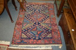 A Persian rug, blue ground with geometric decoration, 150cm x 110cm.