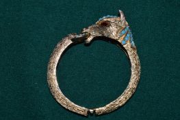 A gilt metal bracelet with ruby eyes.