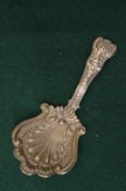An ornate silver tea caddy spoon.