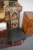 A Victorian rosewood framed prie-dieu with needlework upholstered back panel.