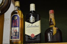 Bottle of Ballantines whisky and two other items.