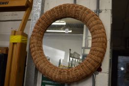 A wicker work framed circular wall mirror.
