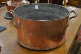 A large copper twin handled pan.