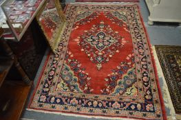 Persian rug, red ground with floral decoration, 215cm x 135cm.