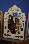 A decorative large mirror with painted pierced frame.