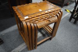 An Indonesian hardwood nest of four tables, the smaller one enclosing a small drawer.