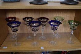 Eight clear and coloured glass hock glasses.