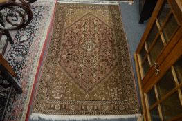 A Persian rug, beige ground with stylised decoration, 163cm x 92cm.