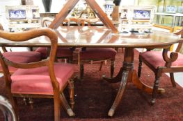 A reproduction mahogany twin pillar extending dining table with two leaves.