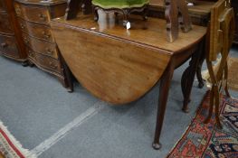 A George III mahogany oval drop-leaf gateleg dining table.