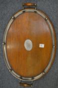 An oak oval twin handled tray with plated mounts.