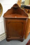 A mahogany corner cabinet with galleried back.