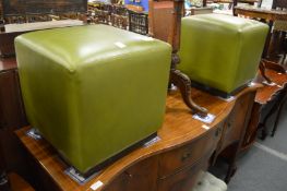 A pair of green leather cube shaped stools.