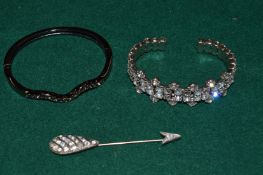 Two diamante bracelets and a pin.