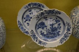 A pair of Chinese blue and white shallow dishes, both with rim chips and cracks.