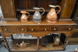 A graduated group of three copper harvest jugs, a copper watering can and a copper coal scuttle.