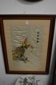 A pair of Chinese framed and glazed embroidered pictures depicting exotic birds.
