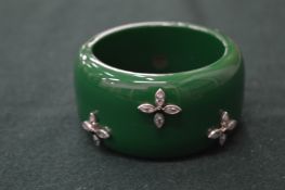 A green bangle, signed.