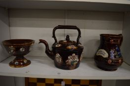 Three items of treacle glazed pottery to include a teapot, bowl and jug.