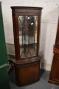 A reproduction mahogany standing corner cabinet.