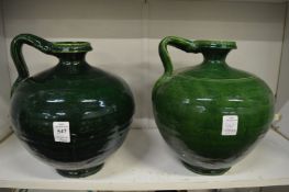 A pair of green glazed pottery jugs.