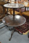A George III design mahogany two-tier circular dumb waiter on carved tripod base.
