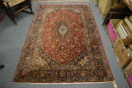 A Persian carpet, red ground with stylised floral decoration, 220cm x 140cm.
