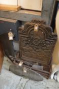 A cast iron fire back and related items.