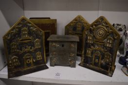 A good collection of brass money boxes, three modelled as houses, one as a fire grate and another as