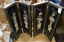 A small Chinese lacquer and mother of pearl four fold screen.