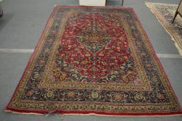 A Persian carpet, red ground with stylised floral decoration, 295cm x 195cm.