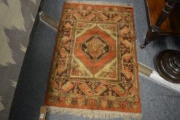 A small Persian style rug, 105cm x 70cm.