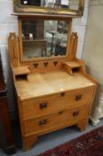 An Arts and Crafts oak dressing chest.