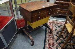 A 19th century mahogany teapoy with rising top revealing two tea compartments above a sewing bag.