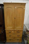 19th century pine linen press with a pair of doors enclosing four sliding shelves, the base with two