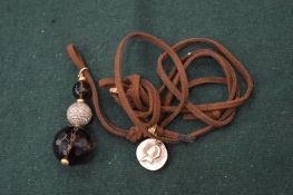 A Brooski leather and bead necklace.