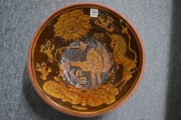 A treacle glazed terracotta bowl with incised decoration depicting animals, the sun and a good