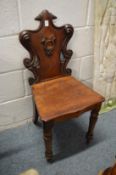 A 19th century mahogany hall chair with carved decoration.