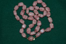A pink stone necklace.