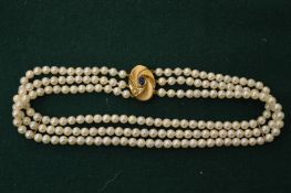 A pearl choker with 18ct gold and cabochon amethyst clasp.