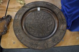 A carved wood circular dish.