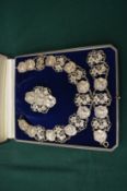 An Art Nouveau silver plated necklace, brooch and bracelet in a fitted case.