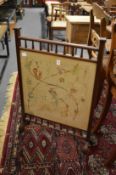 A mahogany framed fire screen with embroidered panel.