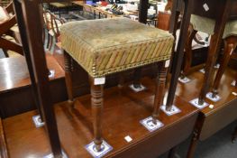A 19th century upholstered stool on turned legs.