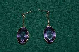 A pair of 9ct gold and amethyst oval shaped earrings.