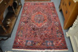 A Persian rug, red ground decorated with flowers, birds and animals, 210cm x 130cm.