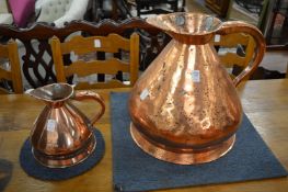 A large copper harvest jug and a similar smaller jug.