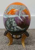 Ostrich egg decorated with images of African game signed Sherry Rowe (with stand)