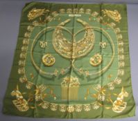 Hermes Les Cavaliers D'or silk scarf depicting gold jewellery on an olive green background -